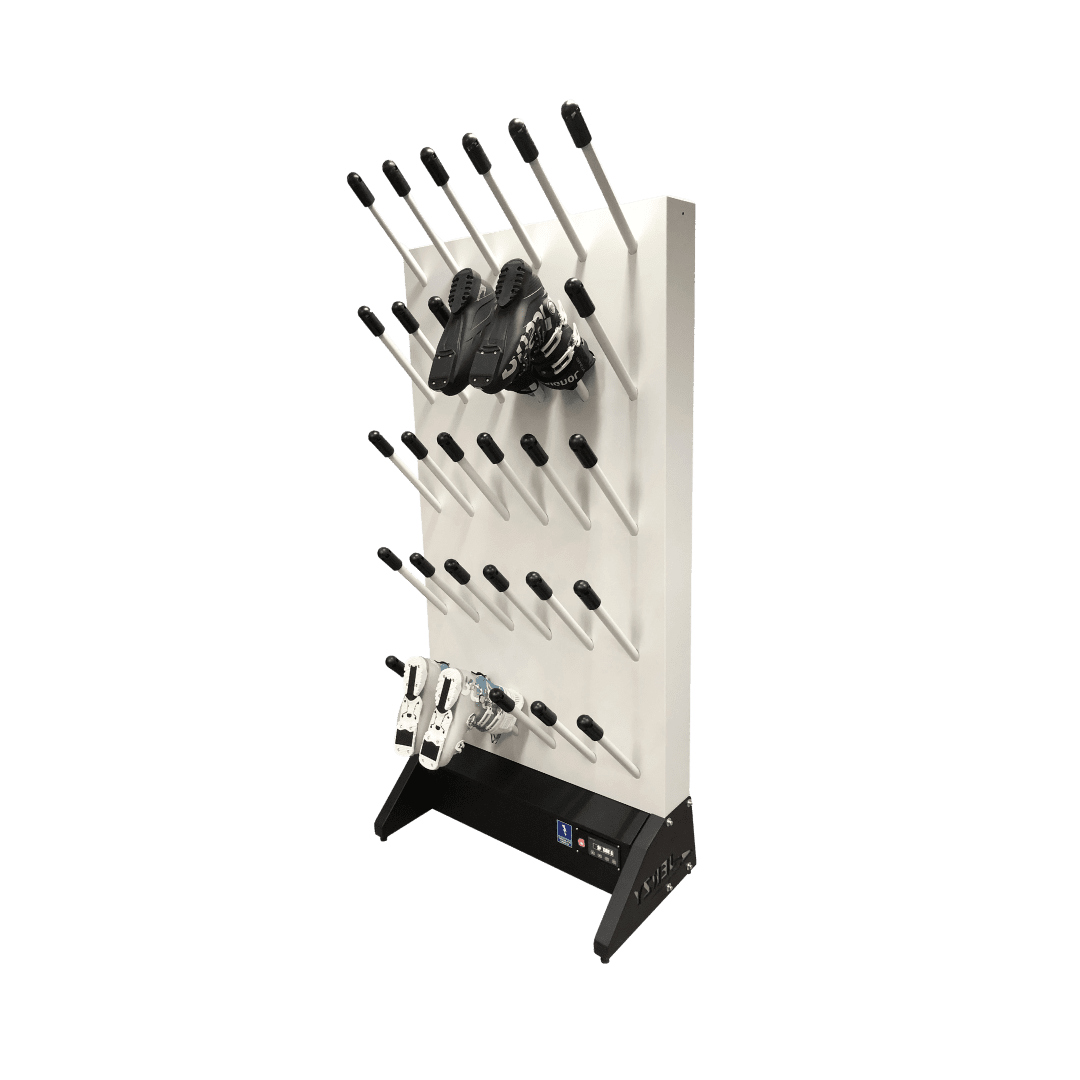 Pionowa suszarka do butów narciarskich, rękawic i kasków, z białym panelem i wieloma czarnymi rurkami do suszenia. Na stojaku widoczne buty i rękawice.