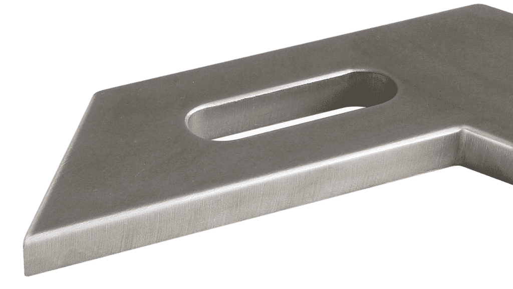 Zbliżenie na metalowy element konstrukcyjny z podłużnym otworem, o matowej, szczotkowanej powierzchni w szlachetnym odcieniu szarości. Widoczne ślady obróbki metalu.